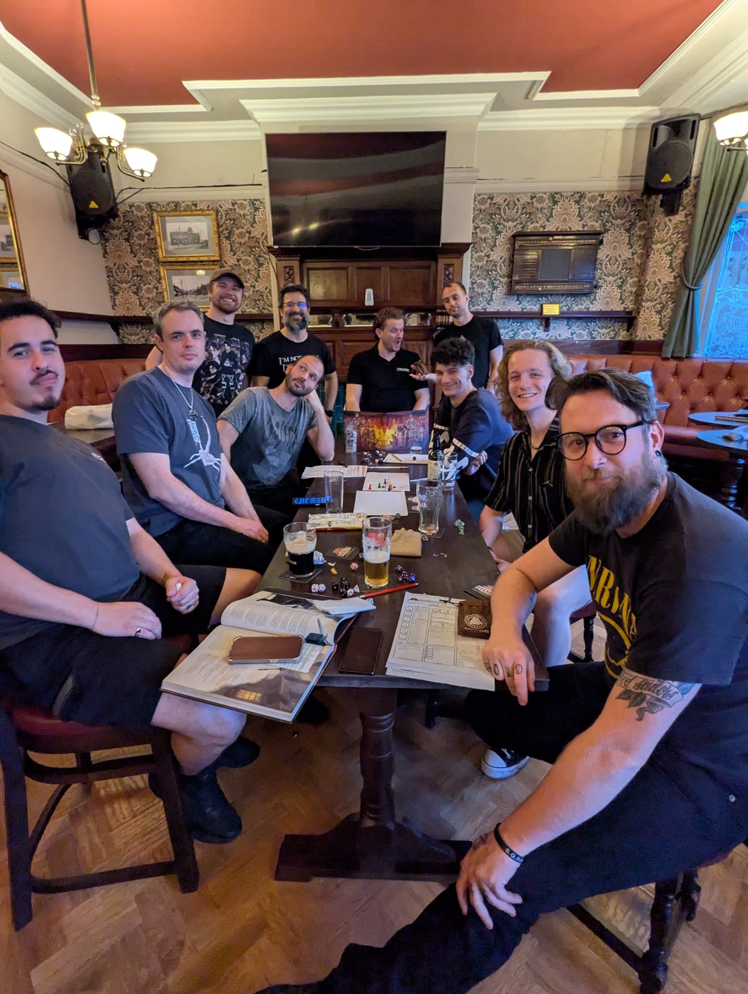 Men gathered around a table playing tabletop games at Quest